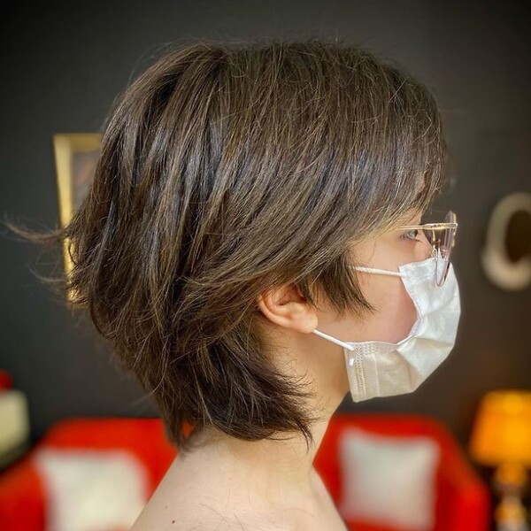 chin length wolf haircut - a woman wearing her eyeglasses and a facemask