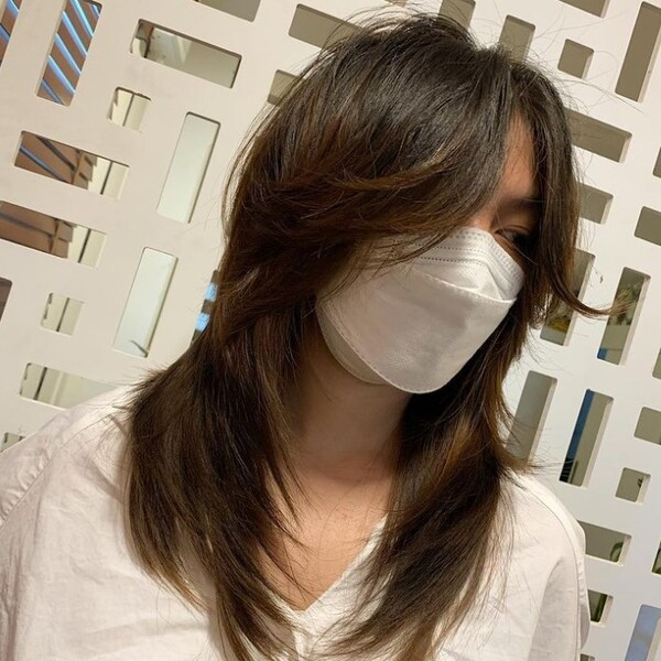 choppy wolf cut - a woman wearing a white blouse and facemask