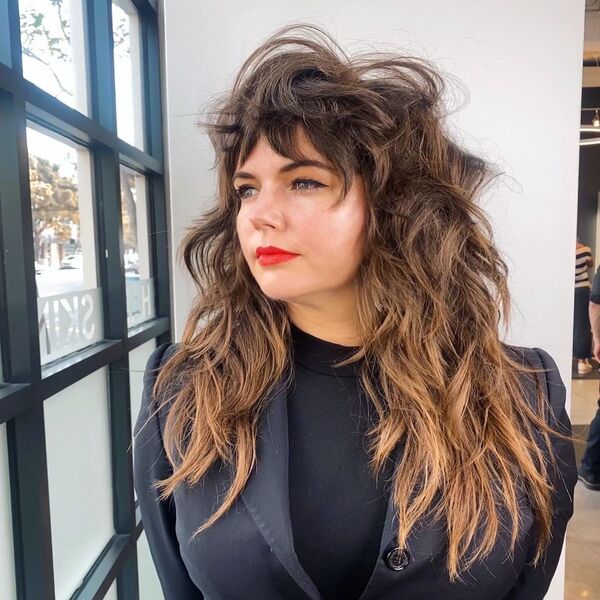 heavily layered wolf haircut - a woman wearing a black corporate suit looking out the window