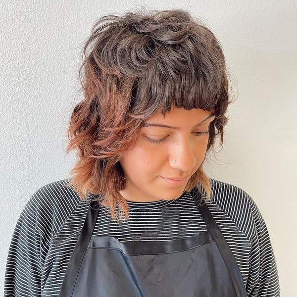 mullet wolf haircut - a woman wearing a black apron and a striped shirt