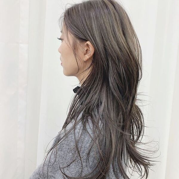 trendy wolf cut for straight hair - a gray haired woman wearing a gray jacket