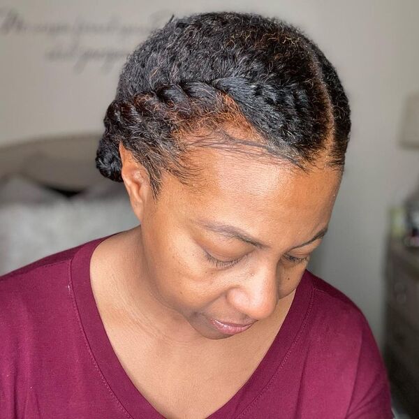 2 Flat Twists Wrapped Into A Bun On Each Side - A woman wearng a maroon shirt