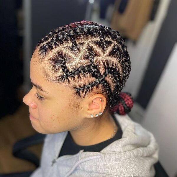 7 Cornrows Feed in Triangles Braid - A woman wearing a color gray hooded jacket and wearing a lot of ear piercings