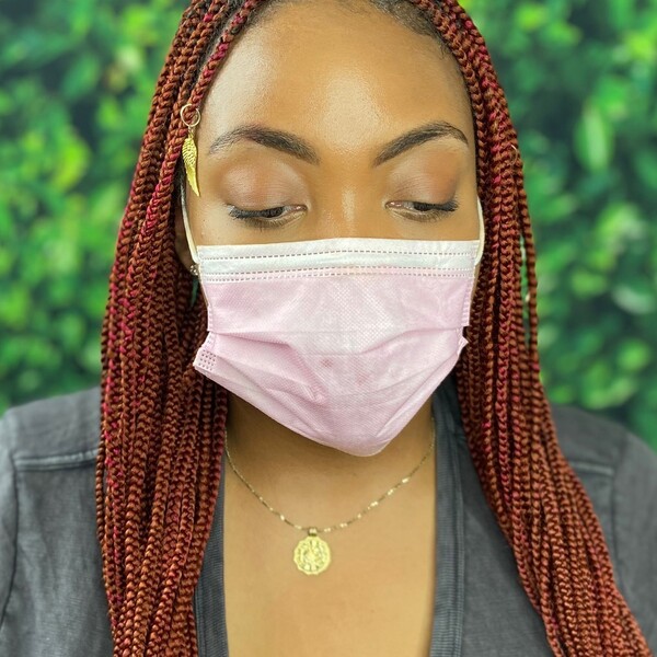 Auburn for Braided Hair - a woman wearing a pink facemask and a gold necklace