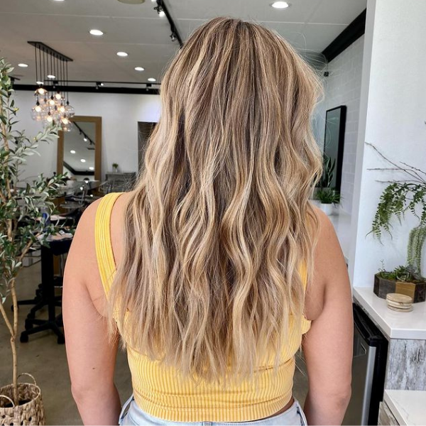 Beachy Waves Mushroom Brown Hair Color - A woman wearing a yellow sexy top