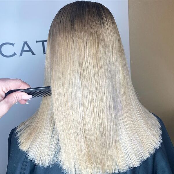 Beige Blonde Highlights Hair Color - A woman wearing a salon cape