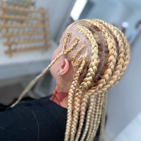 Blonde Freestyle Cornrows Braids - A woman with butterfly tattoo wearing a black shirt