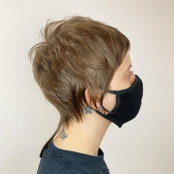 Blue Big Chop Shaggy Pixie with Rat Tail - A woman wearing a black mask
