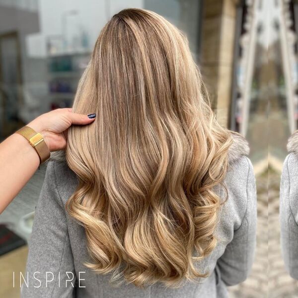 Caramel Ombre Blonde - A woman wearing a grey formal top