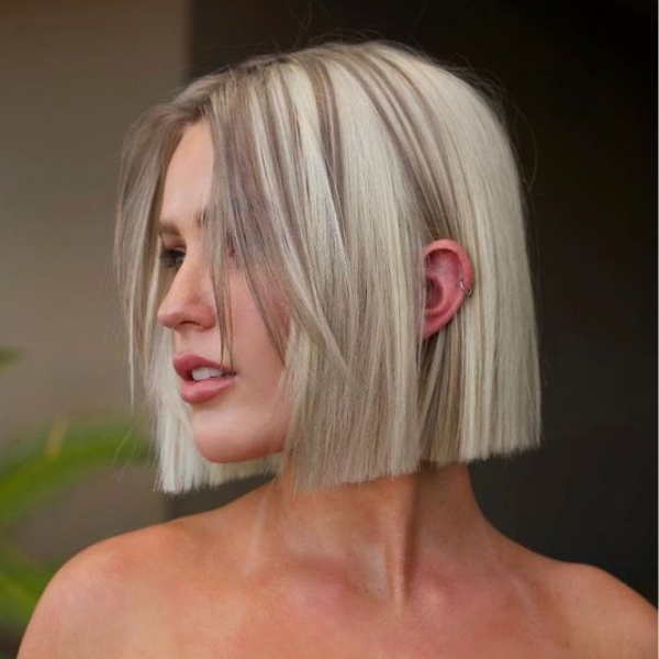 A woman with her dark brown roots balayage bob hairstyle