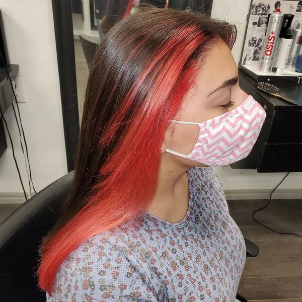 Dark Brown with Strawberry Red Front Hair - A woman wearing a mask inside a salon