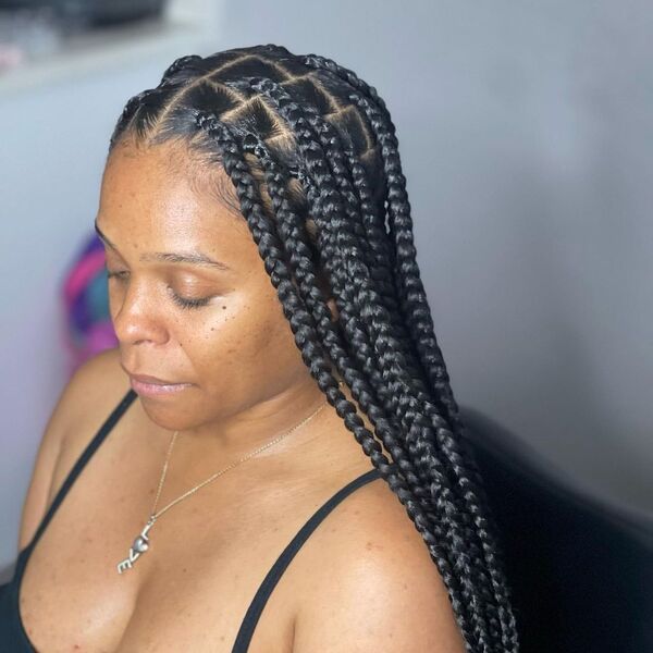 Feed in Box Tribal Braids - A woman with silver necklace wearing a black spaghetti strap