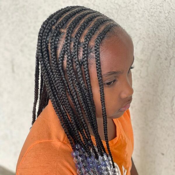 Fulani Braids with Beads - A woman wearing a color orange blouse