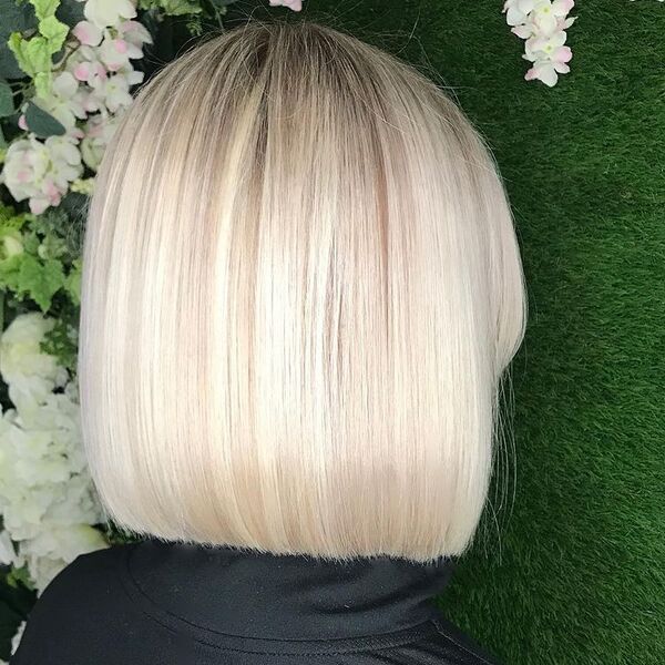 Icy Blonde Bob Curtain Bangs - A woman in her black turtle neck