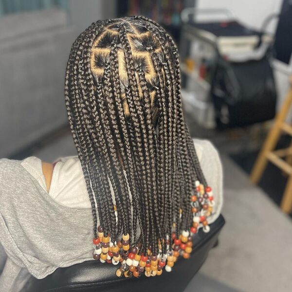 Knotless with Beads Tribal Braids - A woman wearing a gray jacket
