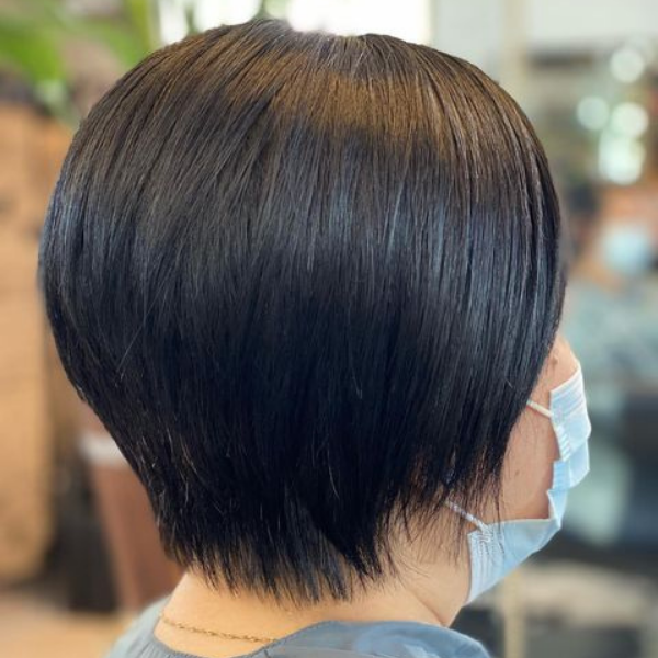 Layered Pixie Haircut for Chubby Face - A woman wearing a blue mask