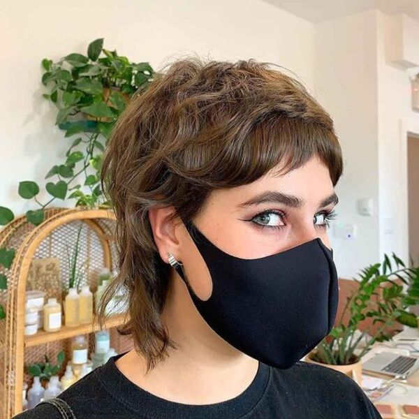 Layered Volume with Feathered Bangs for Pixie Hair - A woman wearing a black mask