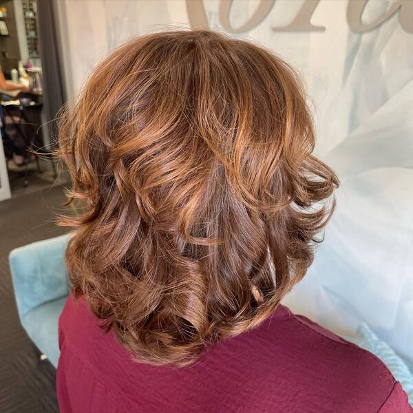 Layered Wavy Light Brown for Short Hair - A woman wearing a violet blouse