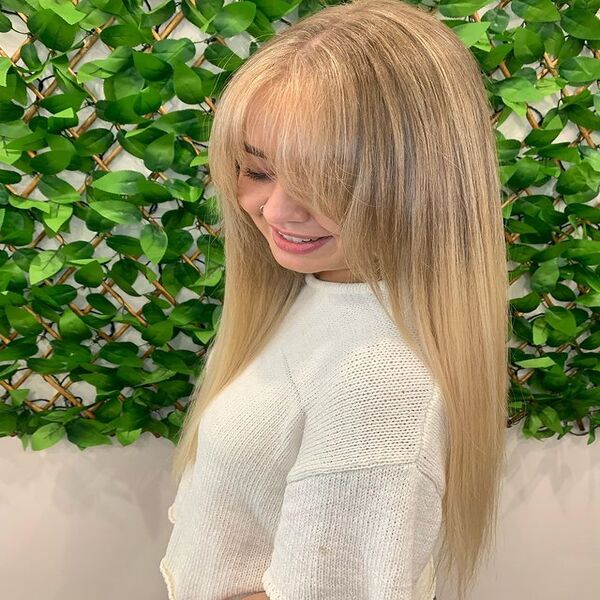 Light Brown Blonde Curtain Bangs Hairstyle - A woman with her white top