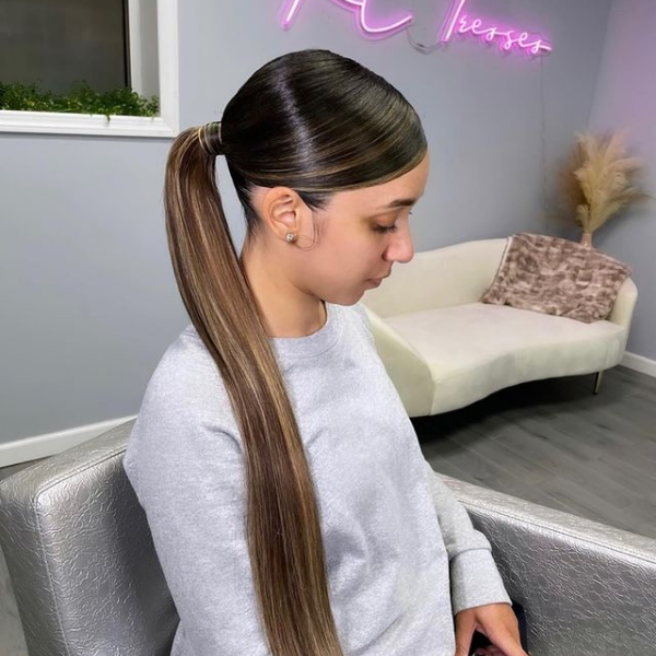 Long Swoop Ponytail with Highlights - A woman wearing a grey jacket