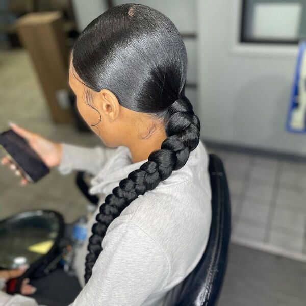 Middle Part Sleek Braided Ponytail with Baby Hair - A woman wearing a gray jacket