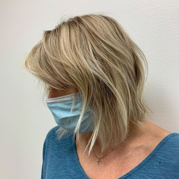 Natural Blonde Short Shag Hairstyle - A woman in her blue top