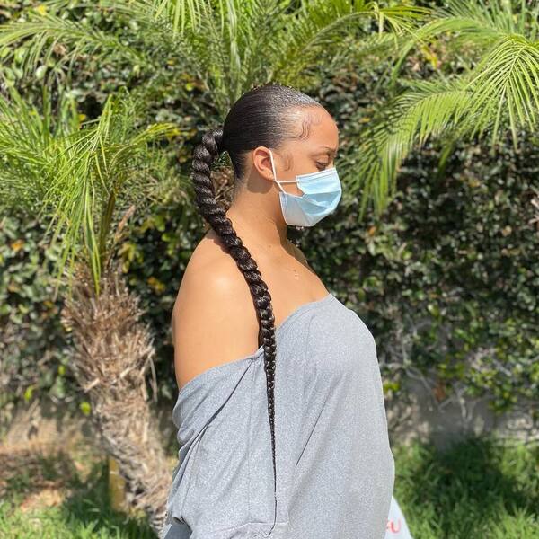 Natural Sleek Ponytail Braid - A woman with blue surgical face mask wearing a gray off shoulder blouse