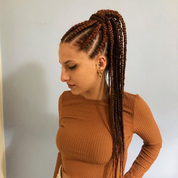 A woman wearing a color rust long sleeve crop top with cornrow braids