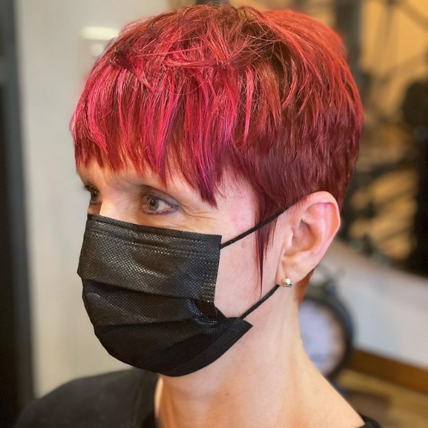 Punky Spicy Red Pixie Hairstyle - A woman wearing a black mask