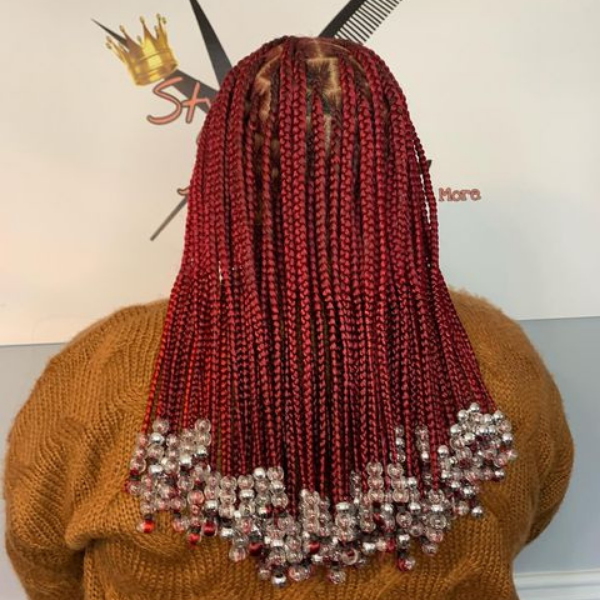 Red Knotless Braids - A woman wearing a knitted top