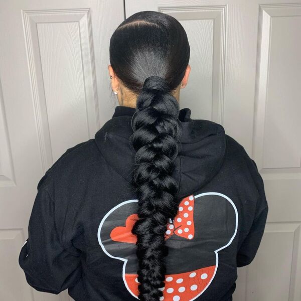 Sleek Butterfly Braid Ponytail - A woman wearing a black printed mickey mouse hooded jacket