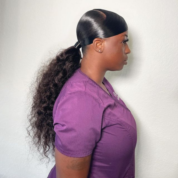 Sleek Swoop Weave Ponytail - A woman wearing a violet top