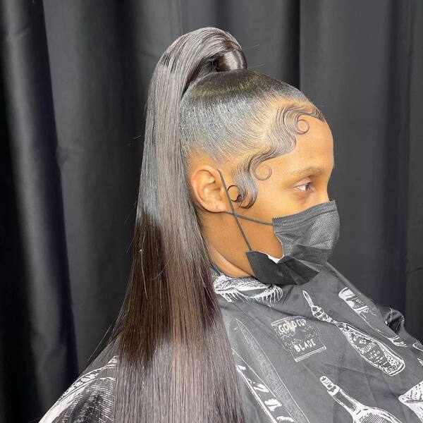 Swoopy Weave Ponytail - A woman wearing a black mask
