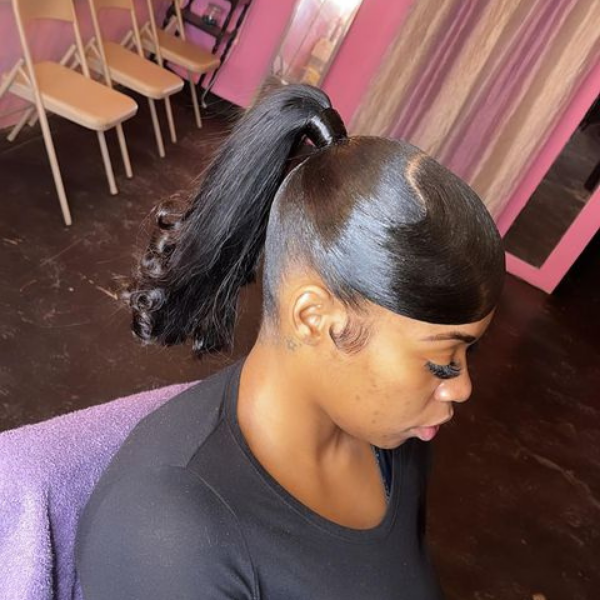 A woman sitting with her top bun long high hairstyle