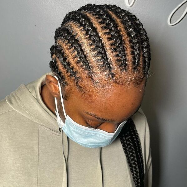 10 Feed in Cornrows Braids - A woman with surgical facemask wearing a cream jacket
