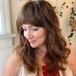50 Beautiful Wavy Hair with Bangs for Women in 2022 - a woman in a side view