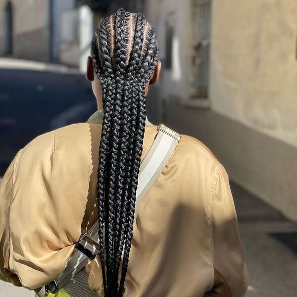 6 Large Straight Back Cornrows Braids - A woman wearing a brown jacket