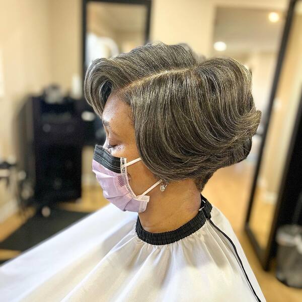 Blunt Feathered Bob with Grey Hair - A woman inside a salon
