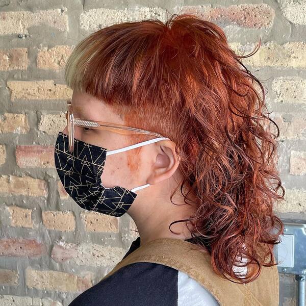 Bowl Cut Curly Mullet With Highlights - a woman in a side view wearing a face mask