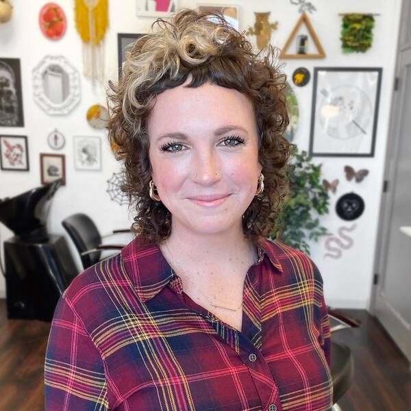 Curly Mullet With Brown & Blonde Tones - a woman wearing a striped polo