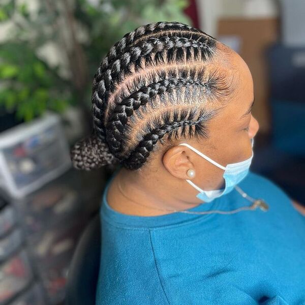 Cornrow Plaits with Small Bun - A woman with surgical facemask wearing a blue shirt