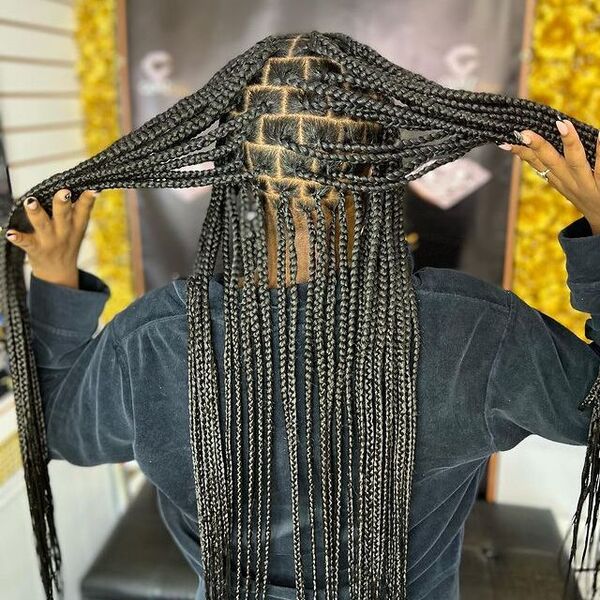 Crispy Clean Part in a Knotless Braids - A woman wearing a faded black sweater