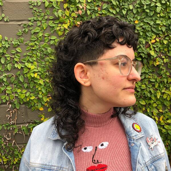 Curly Mullet Shag Hairstyle - a woman wearing a denim jacket
