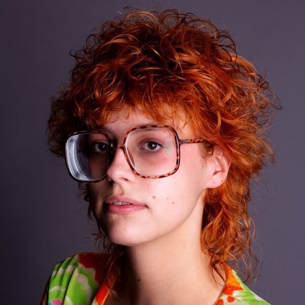 Curly Mullet With Ginger Hairstyle - a woman wearing an eyeglasses