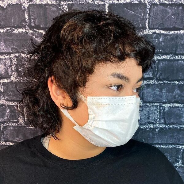 Curly Shaglet Mullet Hairstyle - a woman wearing a face mask