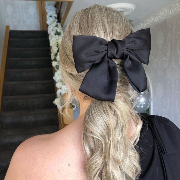 Cute Ponytail Updo with Ribbon - A woman wearing a black sexy top