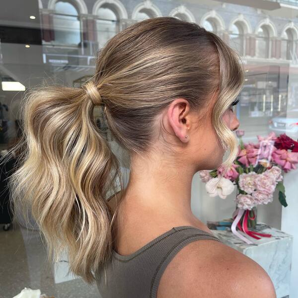 Elegant Ponytail Updo with Bangs - A woman wearing a brown sleeveless top