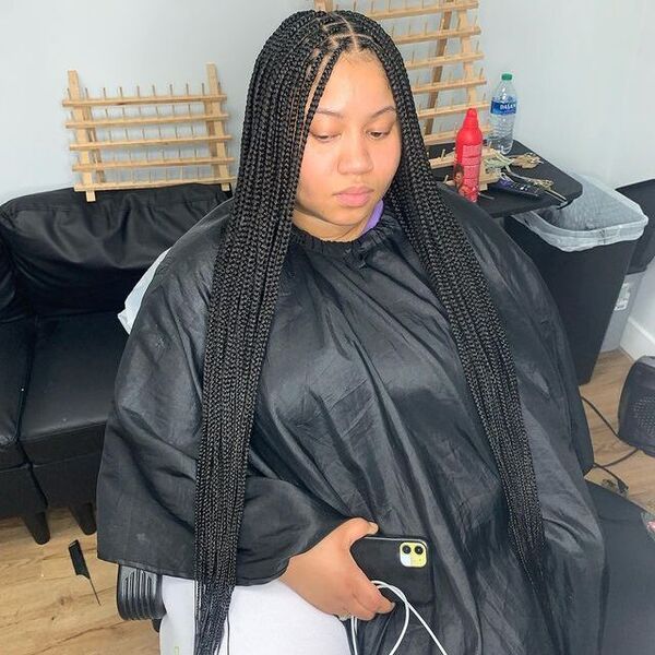 Extra-Long and Medium Knotless Box Braids - A woman wearing a black cape