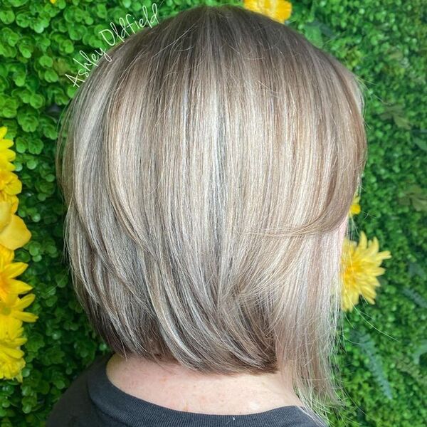 Feathered Short Bob with Partial Highlights - A woman wearing a faded black shirt