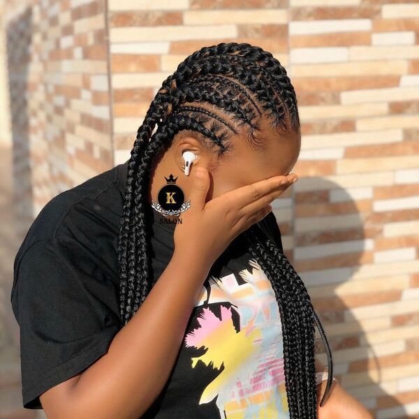 Feed in Braids and Cornrows - A woman wearing a black printed shirt